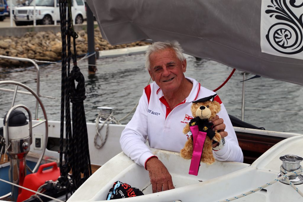 Jon Sanders on yacht with Curtin teddy bear